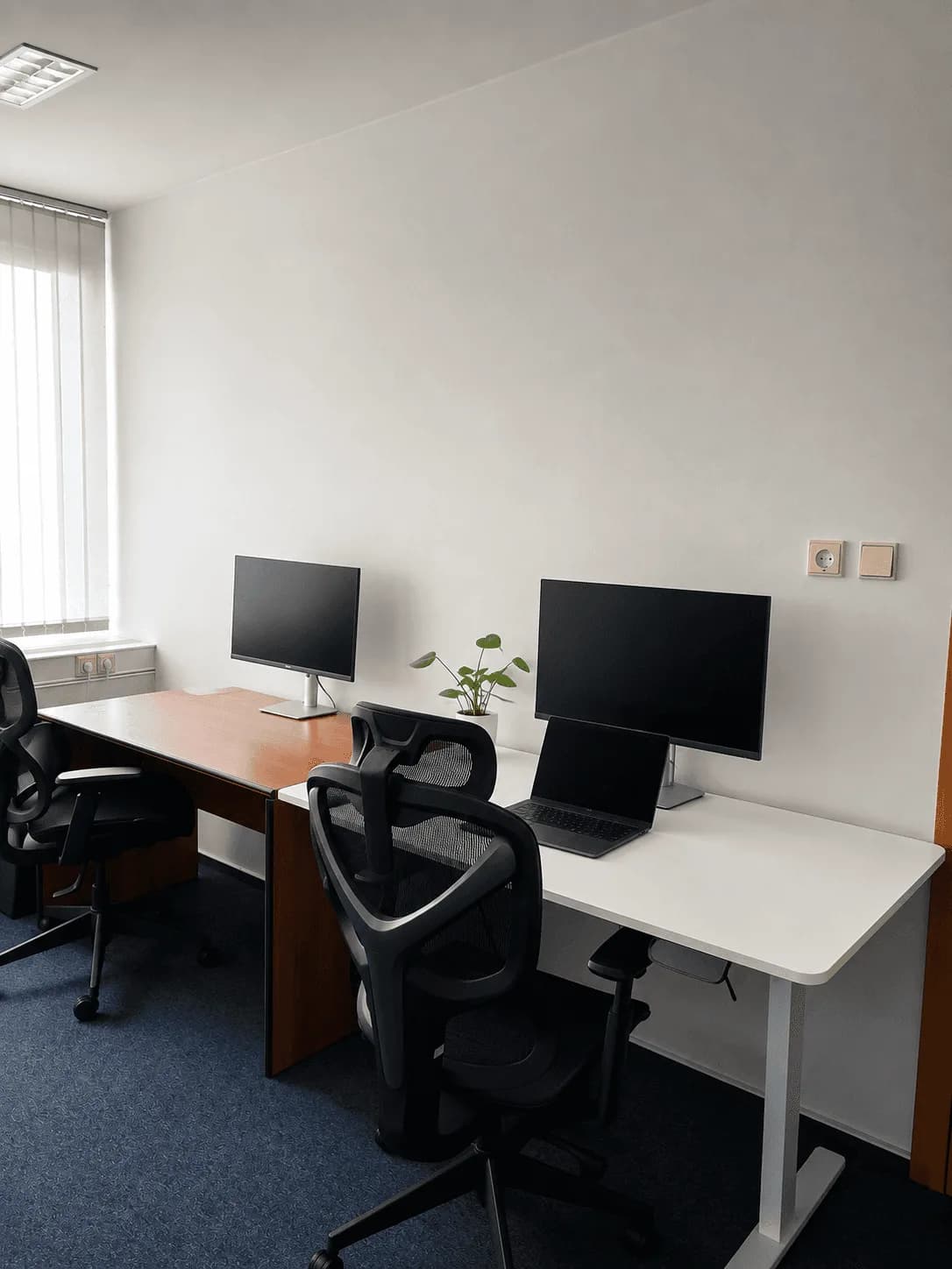 Pracovna se dvěma stoly, monitory a ergonomickými židlemi